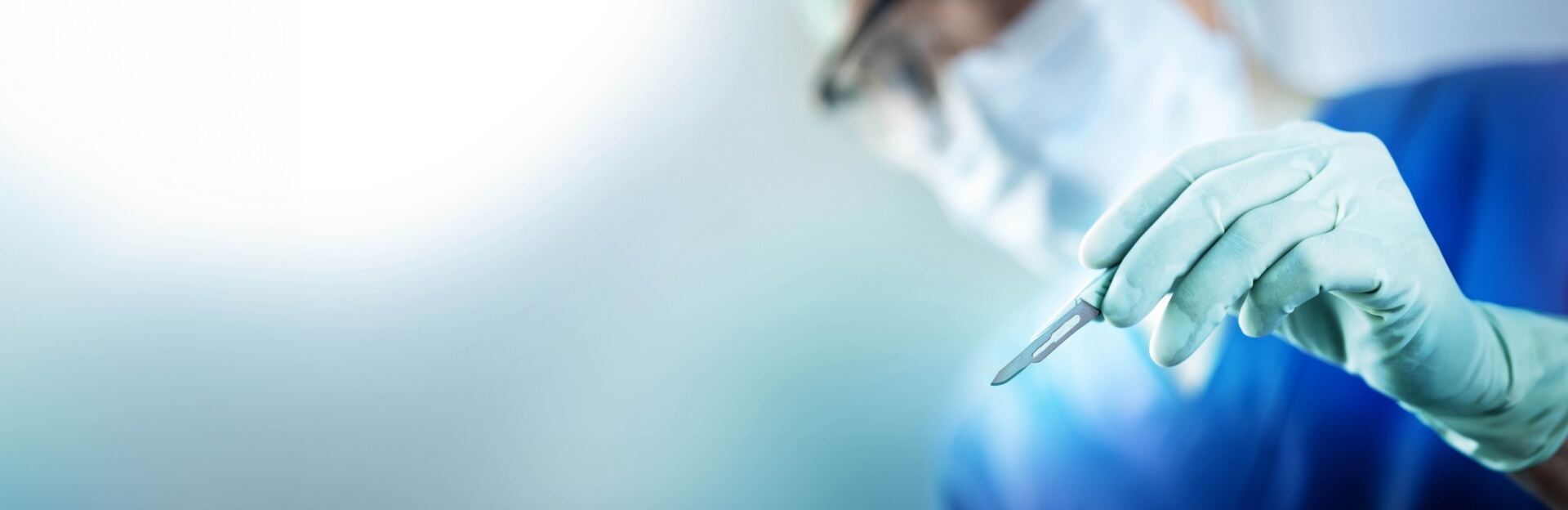 background image of surgeon holding scalpel during surgery