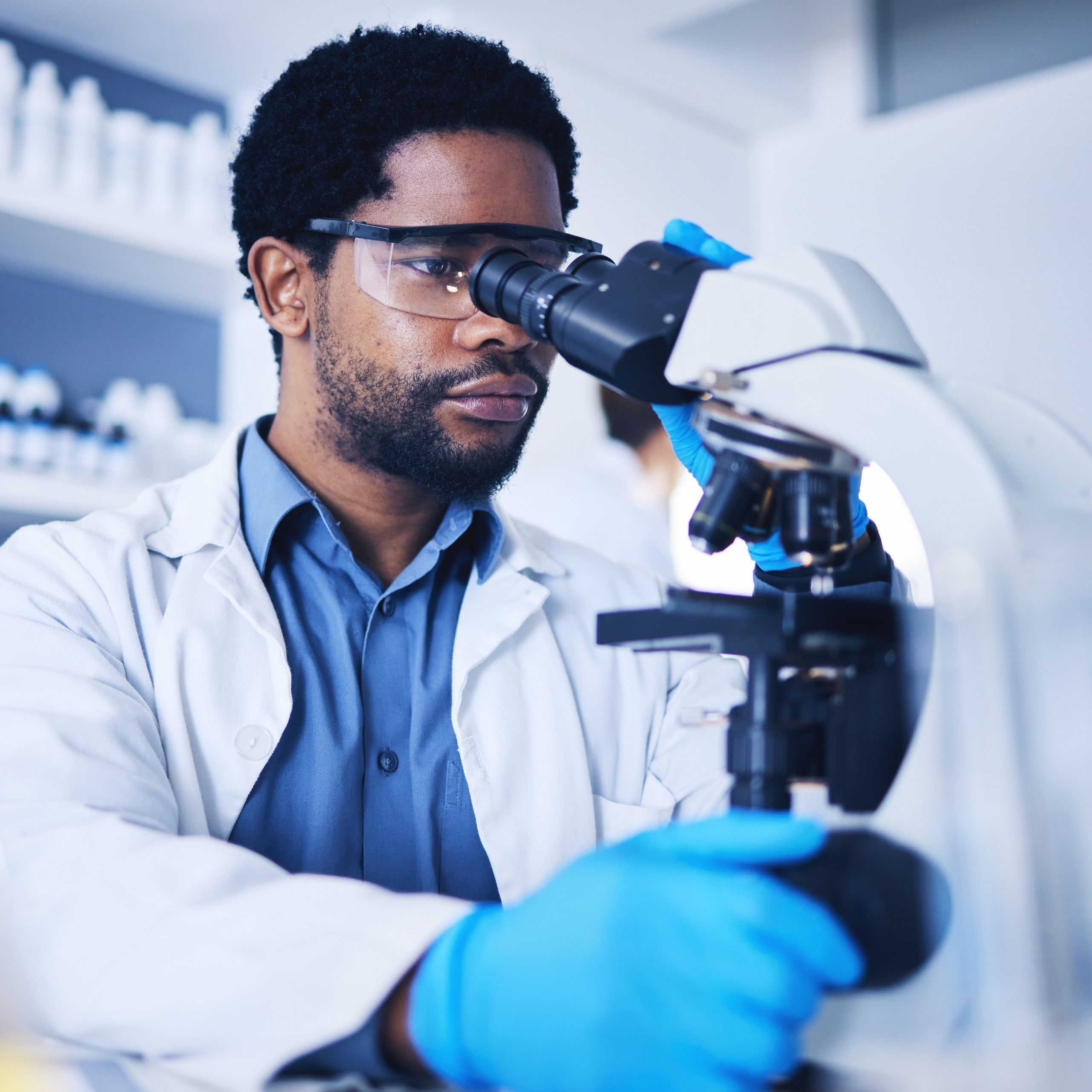Man in a histopathology lab looking through microscope
