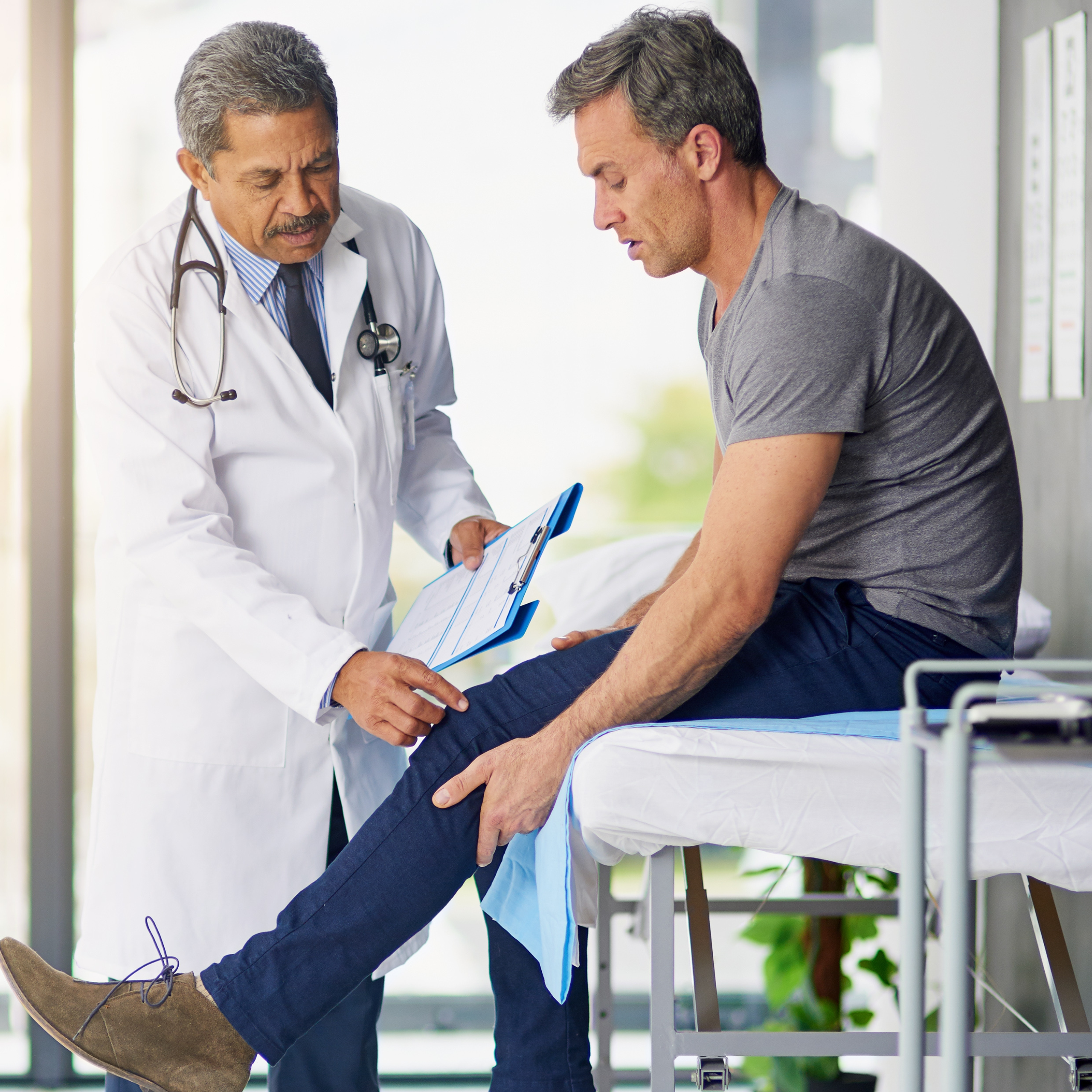 Orthopedic doctor looks at mans knee